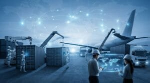 Workers and robots load shipping containers onto trucks and a plane, with digital interfaces and a world map overlay representing global logistics and automation.