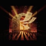 A crowd faces a large, fiery structure with burning currency symbols as papers with dollar, euro, and yen signs fly out, lit dramatically by intense beams of light.
