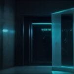 A dimly lit room with a glass door partially open, revealing blue light from an adjacent space.